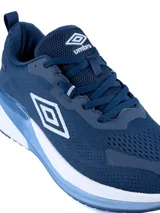 Championes deportivos Umbro modelo Daysprint, color azul marino con detalles en celeste y blanco. Presentan una capellada de malla transpirable, logo lateral de la marca y una suela con amortiguación en tonos blanco y celeste.
