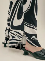 Pantalón ancho con estampado floral en tonos verde y blanco, con pinzas en el frente, bolsillos laterales y elástico en la cintura.