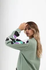 Buzo blanco de corte holgado con cuello redondo y mangas largas con estampado abstracto en negro.