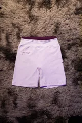 Calza deportiva tipo biker, color dorado metalizado, con tiro alto.