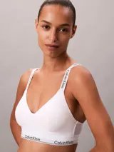 Corpiño Calvin Klein de color blanco, confeccionado en mezcla de algodón y modal. Presenta escote en V, tirantes ajustables y banda elástica inferior con el logo de la marca en contraste.