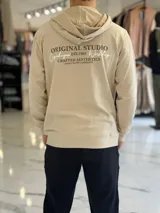 Canguro beige liviano sin felpa, con capucha y estampado en la espalda con el texto "Original Studio Copenhagen Workshop Crafted Aesthetics".