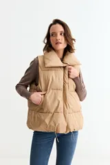 Chaleco puffer de corte holgado y diseño acolchado, con cuello alto y cierre frontal oculto. Presenta cordón ajustable en el ruedo inferior y bolsillos laterales.