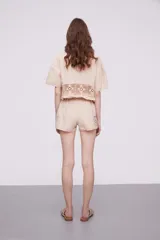 Short blanco de algodón con cintura elástica y detalles de encaje crochet en los laterales y el ruedo.