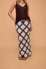 Pollera midi tejida a crochet con diseño de rombos en color marrón y celeste. Tiene elástico en la cintura y llega hasta los tobillos.