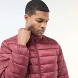 Anorak ligero acolchado de diseño liso, con cuello alto y cierre frontal de cremallera. Presenta un acabado capitoné horizontal y puños elásticos.