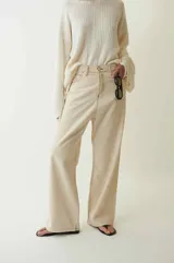 Pantalón de jean color beige claro, tiro medio, con corte ancho y pierna recta. Presenta costuras visibles en tono contrastante.