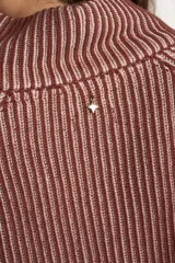 Sweater de punto acanalado color camel, con cuello alto y cierre frontal parcial. Presenta mangas largas con costuras raglán y un corte ligeramente cropped.