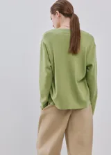Jersey de punto color verde claro con escote en V y mangas largas.
