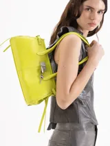 Cartera tipo shoulder bag de cuero vacuno en color amarillo, con doble asa de hombro, cierre superior y detalles de tiras laterales colgantes. Incluye aplique de cerradura metálica con candado y llavero colgante en el frente.