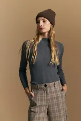Polera de punto acanalado color gris, con cuello alto y mangas largas, de calce ajustado al cuerpo.