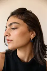 Aros dorados con dije circular de piedra natural negra.