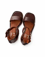 Sandalias de cuero marrón, con punta cuadrada, tira ancha en el empeine y talonera cerrada con cierre y tira con hebilla ajustable.
