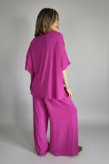 Conjunto fucsia compuesto por un remerón de mangas cortas y un pantalón palazzo de lino.