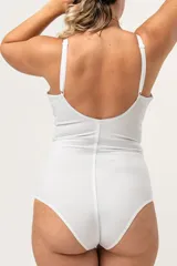 Body modelador blanco de alta contención, sin aro, con breteles elásticos regulables y broches en la entrepierna. Presenta encaje floral en la parte superior del busto y fundillo de algodón.