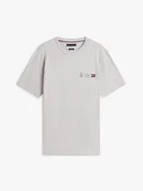 Remera de cuello redondo y manga corta en color gris melange. Presenta un pequeño logo bordado en el pecho que combina un escudo, el nombre de la marca y la bandera característica de Tommy Hilfiger.