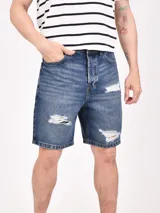 Bermuda de jean azul con efecto desgastado y roturas en los muslos.