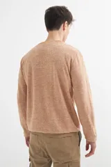 Sweater de punto color naranja claro jaspeado, con cuello redondo y mangas largas.