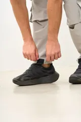 Pantalón cargo color gris claro, de corte amplio, con múltiples bolsillos con solapa y ajuste con cordón en la cintura.