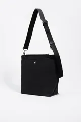 Bolso bandolera de tamaño pequeño confeccionado en nylon, con estructura blanda y cierre de cremallera. Cuenta con asa larga regulable de tejido y logo de la marca aplicado en la parte inferior frontal.