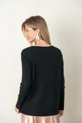 Buzo color verde azulado de tejido de punto fino con frente acanalado y bolsillo con botón de strass.