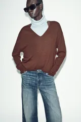 Jeans de tiro bajo, corte recto y largo completo (full length), color azul medio con efecto desgastado y lavado. Modelo de cinco bolsillos con cierre frontal de botones.