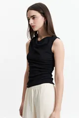 Remera azul con corte asimétrico de un hombro y frunces laterales.