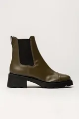 Bota tipo Chelsea de cuero color verde oliva, con paneles laterales elásticos negros y suela track de goma negra con taco cuadrado.