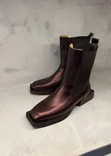 Bota de cuero color cobre, con elástico lateral, caña media, punta cuadrada y suela de madera.