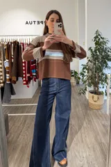 Sweater tejido de punto corto, con cuello redondo y diseño a rayas horizontales en tonos marrón, blanco y celeste.