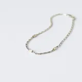 Pulsera de cadena fina de plata 925 con pequeños detalles decorativos en oro distribuidos a lo largo de la pieza.