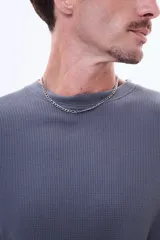 Buzo de manga larga con textura tipo waffle, cuello redondo y corte holgado.