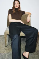 Pantalón de tiro medio con corte wide leg y cintura elástica ajustable. Presenta bolsillos laterales ocultos en las costuras y un diseño de pierna ancha con caída fluida.