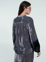 Blusa verde esmeralda de terciopelo con escote en V y mangas largas abullonadas con degradé a negro en los puños.