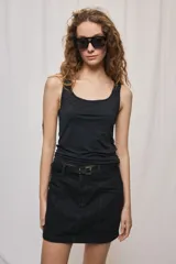 Musculosa de corte entallado en color negro, confeccionada en tejido elástico, con escote redondo y tirantes anchos.