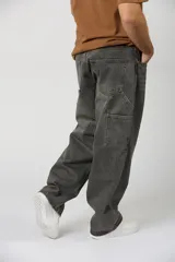 Jean baggy de corte amplio, estilo carpintero, color gris oscuro con efecto acid wash y costuras en contraste.