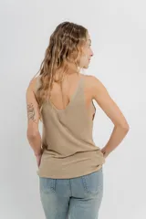Musculosa tejida color amarillo pálido, con escote en V delantero y trasero.
