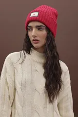 Gorro de punto fucsia con etiqueta de marca en el frente.
