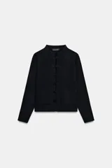 Chaqueta de punto negra de cuello redondo y manga larga, con bolsillos delanteros de parche y cierre frontal con alamares.