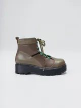 Botas de cuero estilo trekking, en combinación de colores verde, marrón y gris, con plataforma de goma negra, cordones bicolor inspirados en cuerdas de escalada y pasadores en tono rojizo.