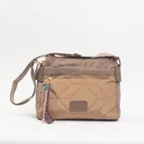 Bandolera color camel con diseño acolchado de rombos en el frente y cierre metálico. Cuenta con correa ajustable, herrajes dorados y un detalle de borla de cordones multicolor colgando del cierre frontal.