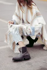 Bota tipo chelsea de cuero color marrón oscuro, con paneles laterales elásticos y suela track robusta con plataforma.