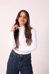 Polera blanca de cuello alto y mangas largas, de tejido acanalado.