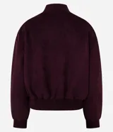 Campera tipo bomber de gamuza sintética color bordó, con cierre frontal de botones a presión, cuello, puños y cintura con tejido acanalado elástico.