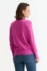 Sweater de punto fino en color verde menta, con cuello redondo, mangas largas y puños acanalados con detalle de botones metálicos laterales.