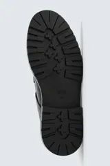 Zapato tipo Mary Jane color negro, con cierre mediante hebilla lateral, parte superior fabricada en piel, detalle de bordón en el empeine, horma redonda y suela con volumen.