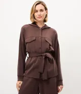 Campera deportiva Get Over de color negro, confeccionada en mezcla de poliéster, modal y elastano. Presenta diseño utilitario con capucha, cierre frontal de botones, bolsillos con solapa en el pecho, mangas largas y lazo ajustable en la cintura.