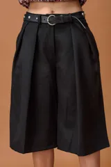 Bermuda de tiro alto color negro, con diseño amplio y tablas delanteras. Incluye un cinturón de cuero sintético con hebilla metálica y detalles de tachas plateadas.