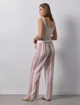 Pantalón de lino de la marca Marissa Olivia, con pretina ancha elastizada y lazo de ajuste. Diseño a rayas verticales en blanco, rojo y azul. Cuenta con bolsillos inclinados en la parte delantera.