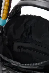 Cartera tote mini negra, con diseño matelasse y dos asas cortas. Incluye una correa larga ajustable y extraíble, con detalles de cuentas de colores.